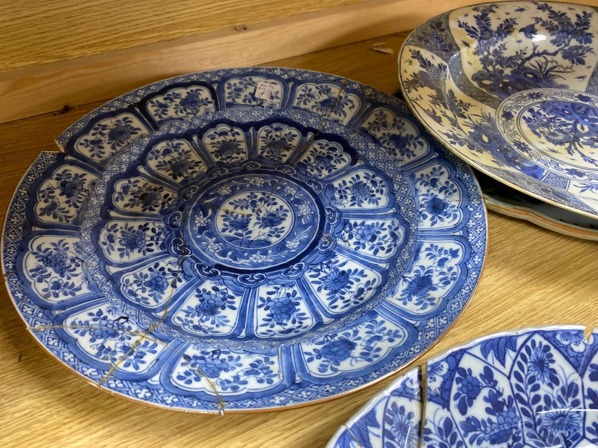 Four Chinese Kangxi period blue and white dishes and a Qianlong blue and white dish